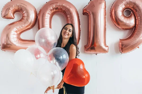 Молодая женщина с воздушными шарами позирует празднуя Новый год — стоковое фото