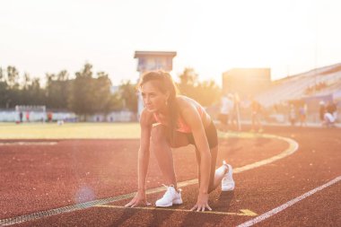 Stadyumda çalıştırmak için hazır başlangıç pozisyonuna içinde kadın.