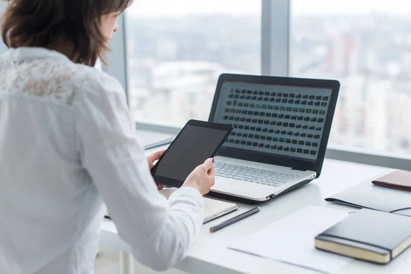 Женщина, работающая с планшетным ПК и ноутбуком на столе — стоковое фото