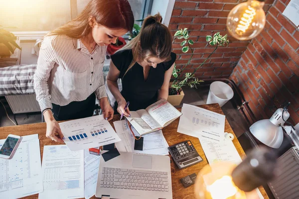 Bovenaanzicht Van Geconcentreerde Jonge Vrouwen Die Aan Tafel Zitten Samenwerken — Stockfoto