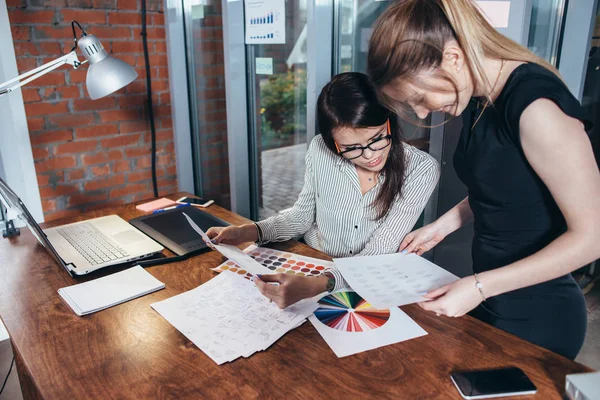 Equipo creativo de diseñadores gráficos que trabajan en un nuevo proyecto utilizando muestras de color y bocetos de diseño de elementos del sitio web — Foto de Stock