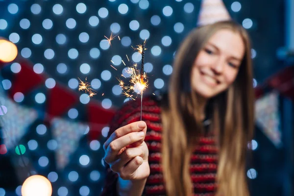 線香花火を手で保持している陽気な若い女性。クリスマス新年 — ストック写真