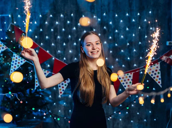 Jovencita alegre sosteniendo chispeante en la mano. Navidad Año Nuevo —  Fotos de Stock
