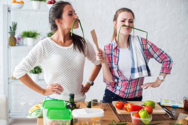 Kadınlar sağlıklı yiyecekler hazırlıyorlar mutfakta sebzelerle oynuyorlar beslenme konsepti oluşturuyorlar.