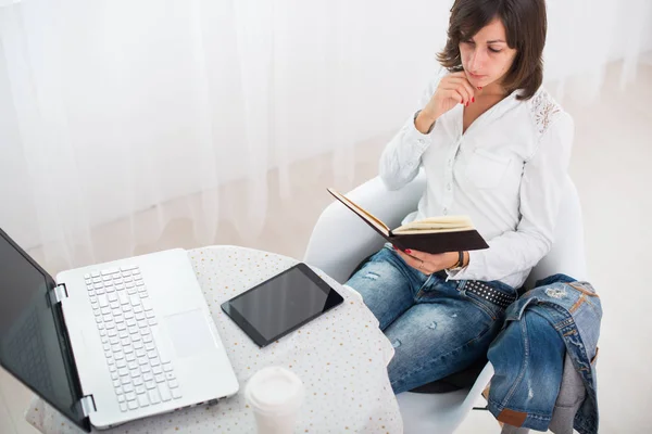 女商人与笔记本电脑和日记在一个明亮的办公室自由职业者工作在家里. — 图库照片