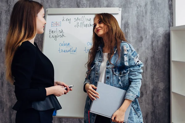 English language school. Two female students talking in classroom. — Stock Photo, Image