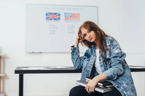 Vrouwelijke student met boeken in de klas Engelse taalschool. — Stockfoto