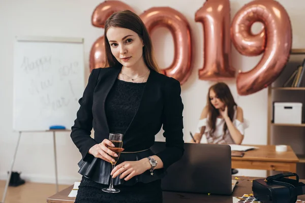 Porträt einer jungen Frau mit Weinglas, die im Büro feiert. Weihnachten, Christmette, Neujahr. — Stockfoto