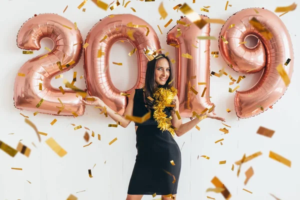 Mulher de vestido preto e coroa amarela celebrando o ano novo, se divertindo — Fotografia de Stock