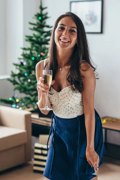 Το νέο έτος. Νεαρή γυναίκα με ένα ποτήρι σαμπάνια. Γιορτάζει και χαμογελαστός. Χριστούγεννα. — Φωτογραφία Αρχείου