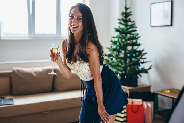 Χριστούγεννα, Πρωτοχρονιά. Ευτυχισμένη γυναίκα με ποτήρι σαμπάνια στο σπίτι — Φωτογραφία Αρχείου