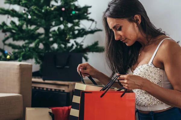 女性のクリスマス ツリーが立地、ショッピング バッグのプレゼント — ストック写真
