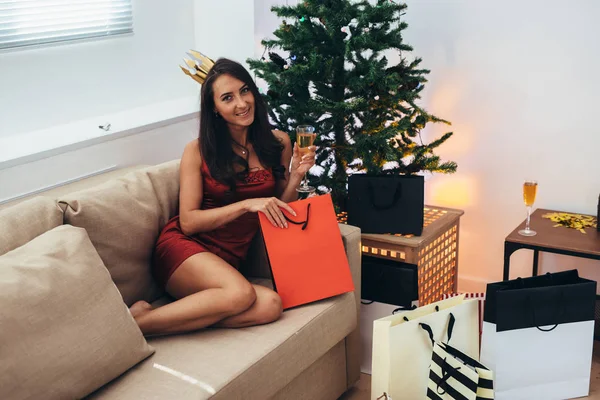 Jonge vrouw met boodschappentassen in de buurt van de kerstboom. — Stockfoto