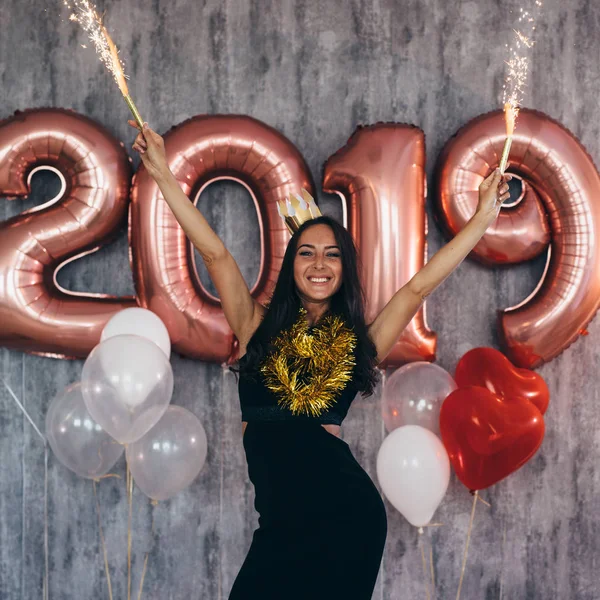 Happy young woman holding balloons Holiday party