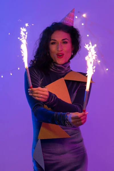 Glücklich lächelnde Frau, die mit Feuerwerk feiert. Neujahrsfeier. — Stockfoto