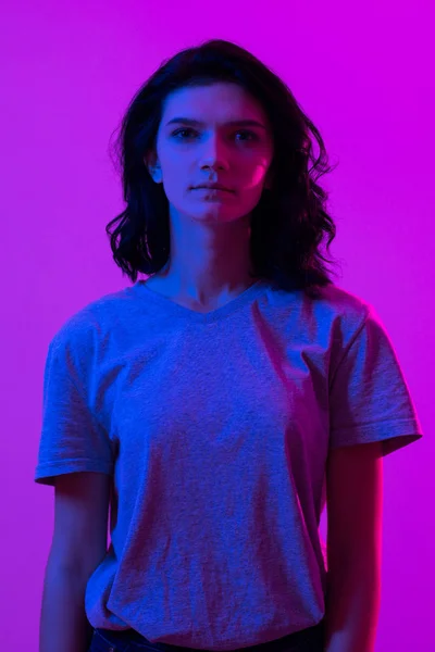 Portret van een mooie vrouw. Roze, paarse en blauwe lichtkleuren. — Stockfoto