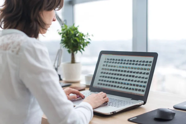 Trabajadora de oficina escribiendo, trabajando en su lugar de trabajo, usando laptop . —  Fotos de Stock