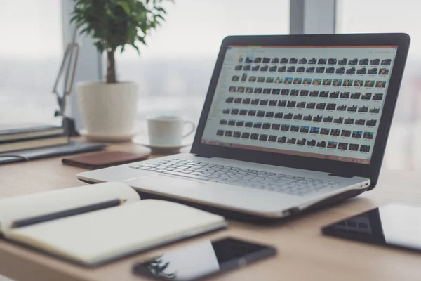 Arbetsplats med notebook laptop bekväm arbetsbordet i office windows och stadsutsikt. — Stockfoto