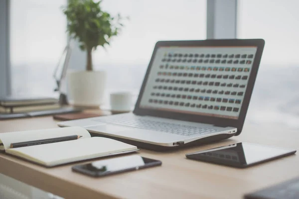 Arbetsplats med notebook laptop bekväm arbetsbordet i office windows och stadsutsikt. — Stockfoto