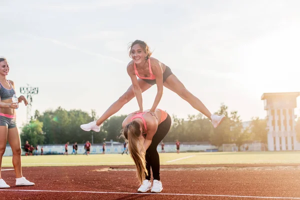 Passa kvinnor på stadion spela hoppa groda. — Stockfoto