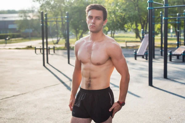 Fitness man die zich voordeed op straat fitness station tonen zijn gespierd lichaam — Stockfoto