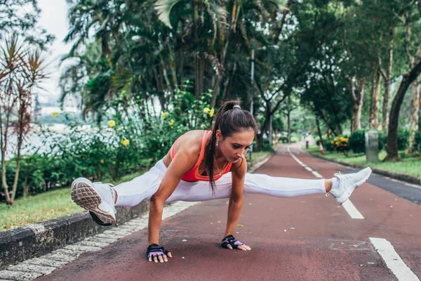 Спортивная молодая женщина делает упражнения на руках в светлячке postu — стоковое фото