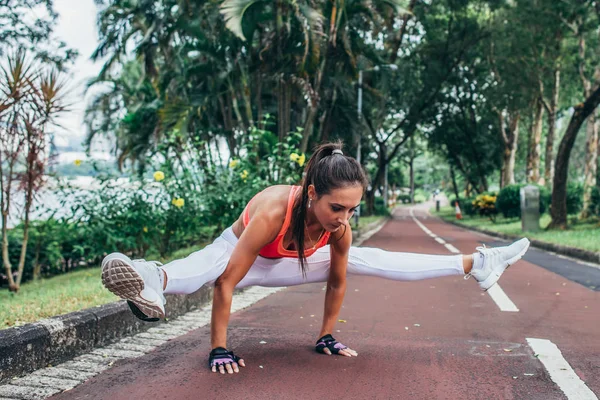 Deportiva mujer joven en forma haciendo ejercicio de pie de manos en la luciérnaga postu — Foto de Stock