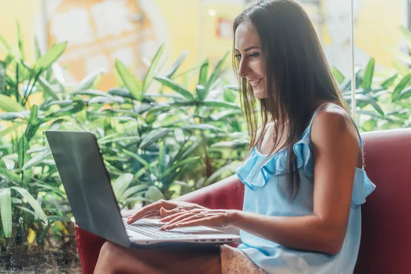 Jovem mulher trabalhando com laptop sentado no café — Fotografia de Stock