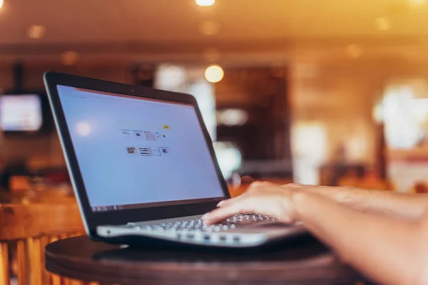 Ritratto di giovane freelance che lavora su laptop seduta in un bar — Foto Stock