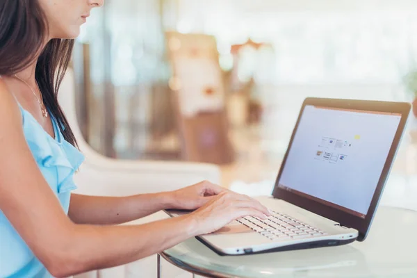 Retrato de una joven freelancer trabajando en una laptop sentada en una cafetería — Foto de Stock