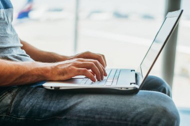 Havaalanı terminal dizüstü bilgisayar kullanan genç adam