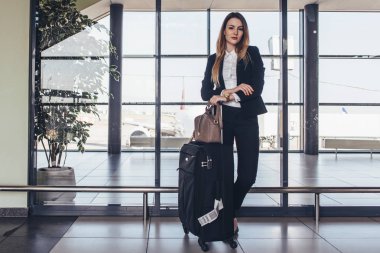 Güzel airhostess çantasını bir uçuş için hazır ile onun üniformalı ayakta