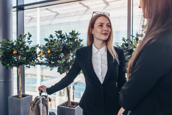 Zwei lächelnde Geschäftspartner sprechen im Stehen am Flughafen — Stockfoto