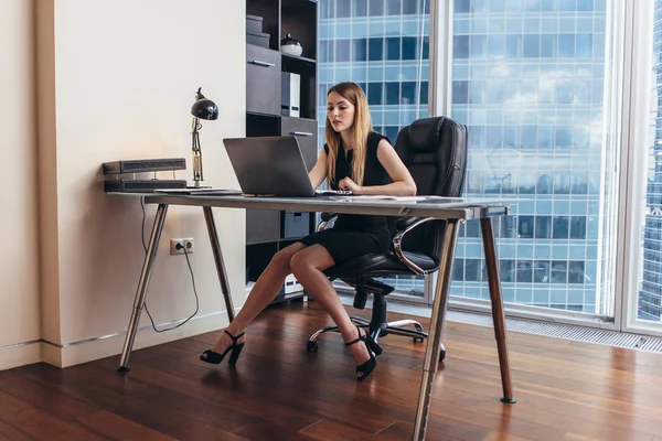 Mujer joven que trabaja en el ordenador portátil estudiando datos financieros y estadísticas de la empresa — Foto de Stock