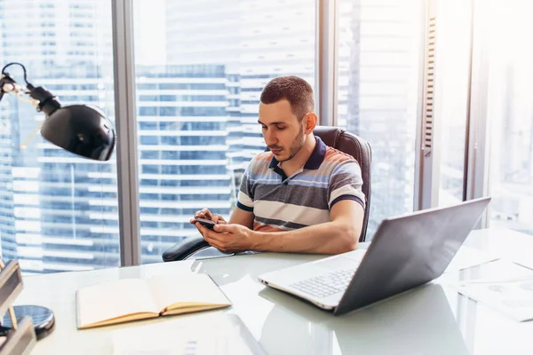 Workday de analista financiero escribiendo en la computadora analizando el trabajo con estadísticas sentadas en el lugar de trabajo contra ventana con vista de paisaje urbano —  Fotos de Stock