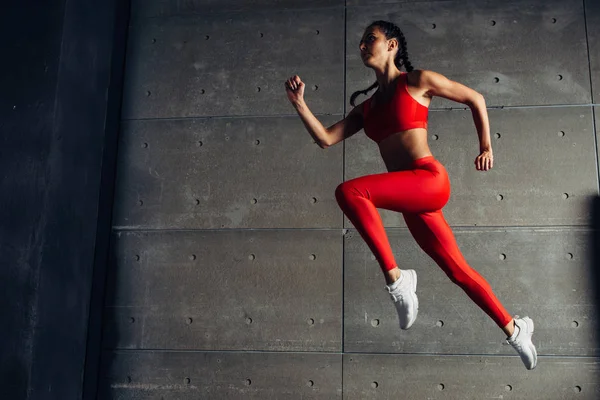 Jovem mulher apto pulando enquanto corre Fitness esporte menina exercitar . — Fotografia de Stock