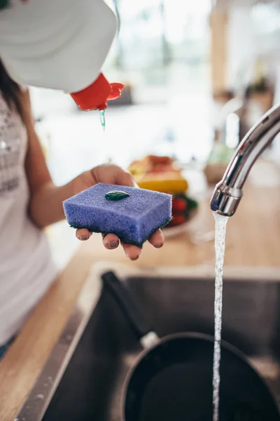 Woman putting cleanser to a sponge. Hand washing dishes — Stock Photo, Image