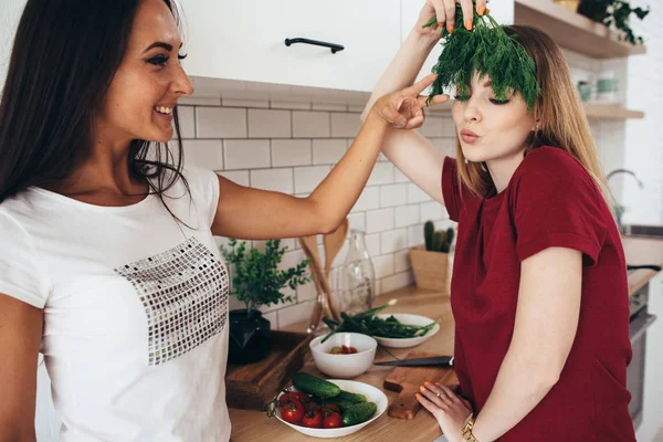 Vrouwen in de keuken grap, lachen en plezier hebben. Spelen met groenten — Stockfoto