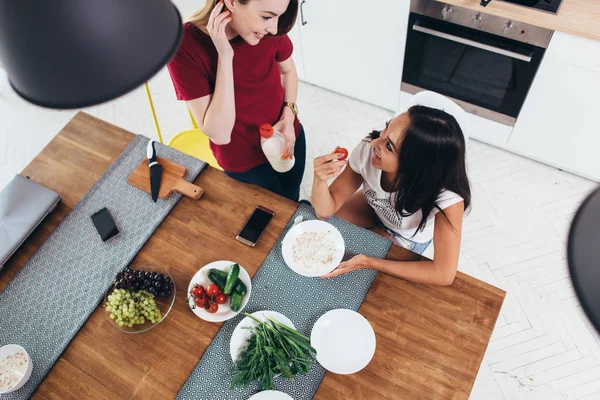 Two women having breakfast at home in the kitchen — Stock Photo, Image