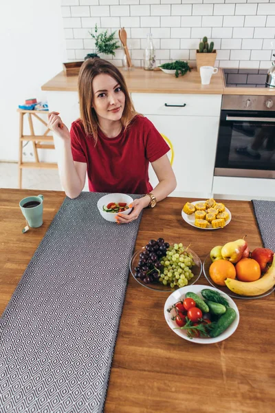 Женщина дома ест фрукты и овощи вид сверху . — стоковое фото