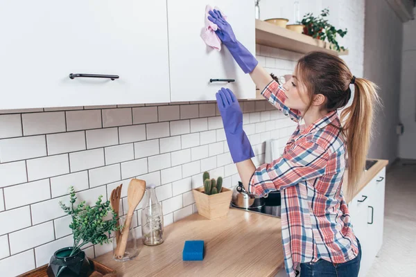 Young woman cleaning the furniture in the kitchen. — Stock Photo, Image