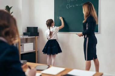 Okul ders öğretmen ve öğrenci bir tahtaya yazmak