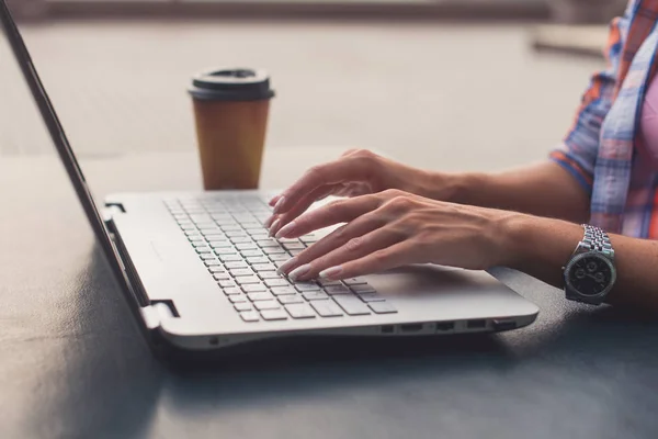 Jovem usando um laptop trabalhando ao ar livre. Feminino olhando para a tela e digitando no teclado . — Fotografia de Stock