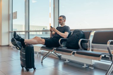 Havaalanında ki geliş salonunda biniş bekleyen adam