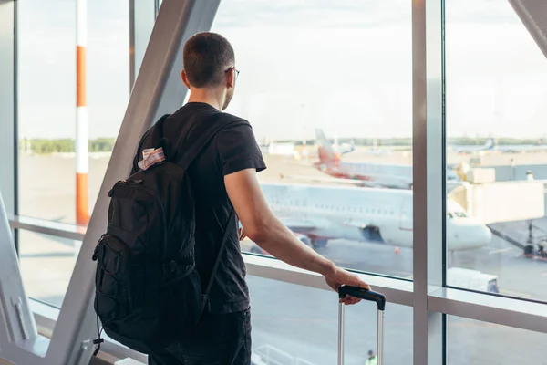 Joven parado cerca de la ventana en el aeropuerto — Foto de Stock