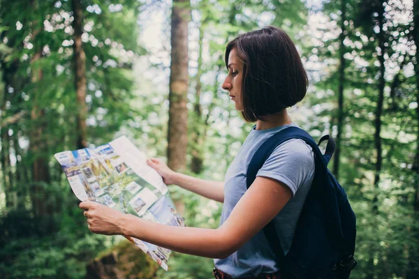 Mulher olhando para o mapa enquanto caminhava na floresta . — Fotografia de Stock