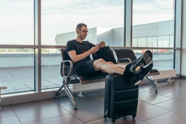 Gelen yolcu salonunda dinlenen adam havaalanında nakil bekliyor