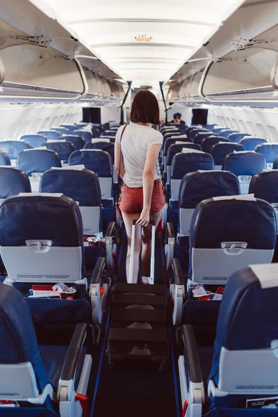 Vista trasera de la joven mujer caminando por el pasillo en avión —  Fotos de Stock