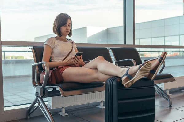 Mujer esperando embarque en la sala de llegadas en el aeropuerto — Foto de Stock