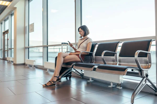 Mujer descansando en la sala de llegadas esperando un traslado en el aeropuerto — Foto de Stock